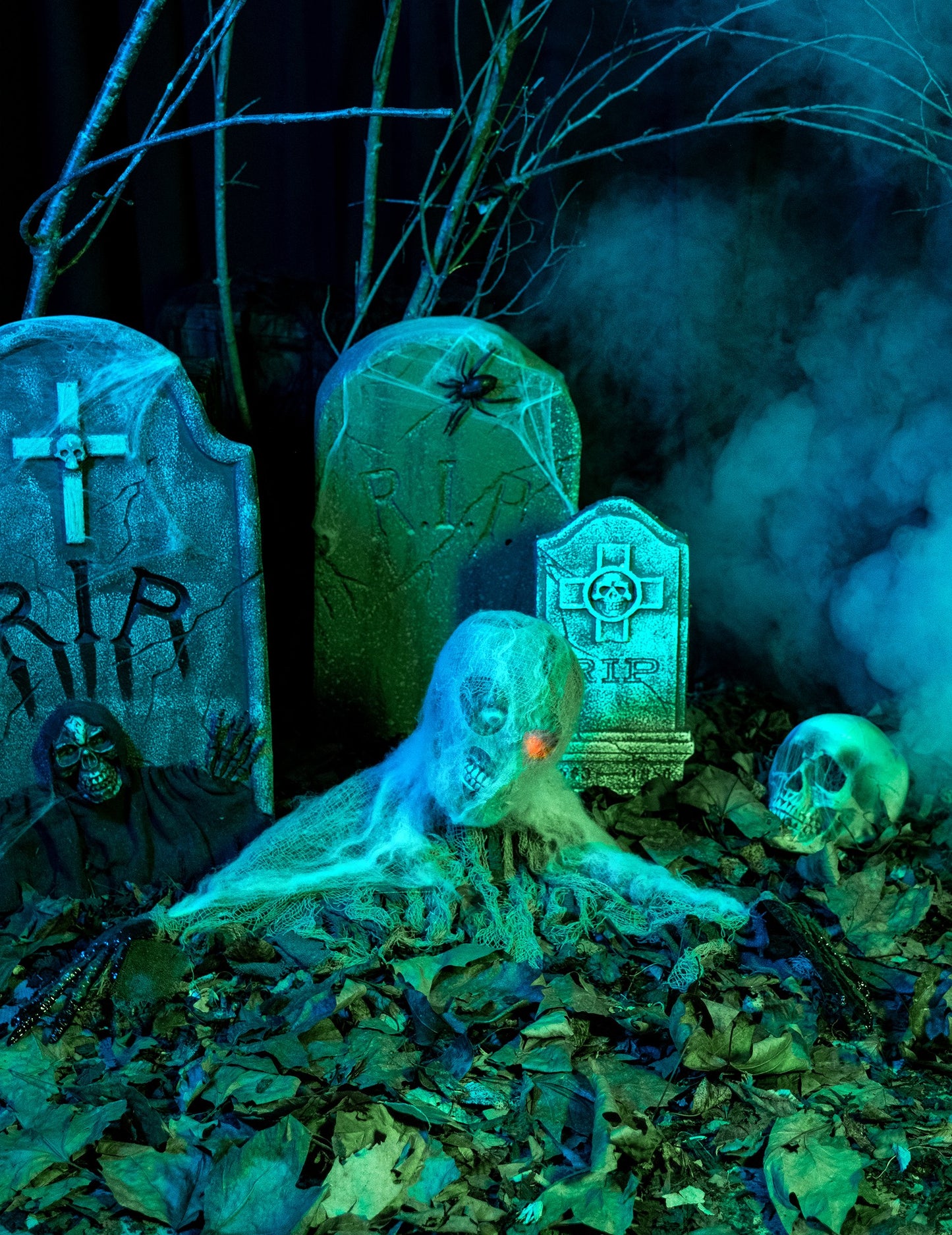 Mlhavá atmosféra na hřbitově s animovanou zombie dekorací na Halloween