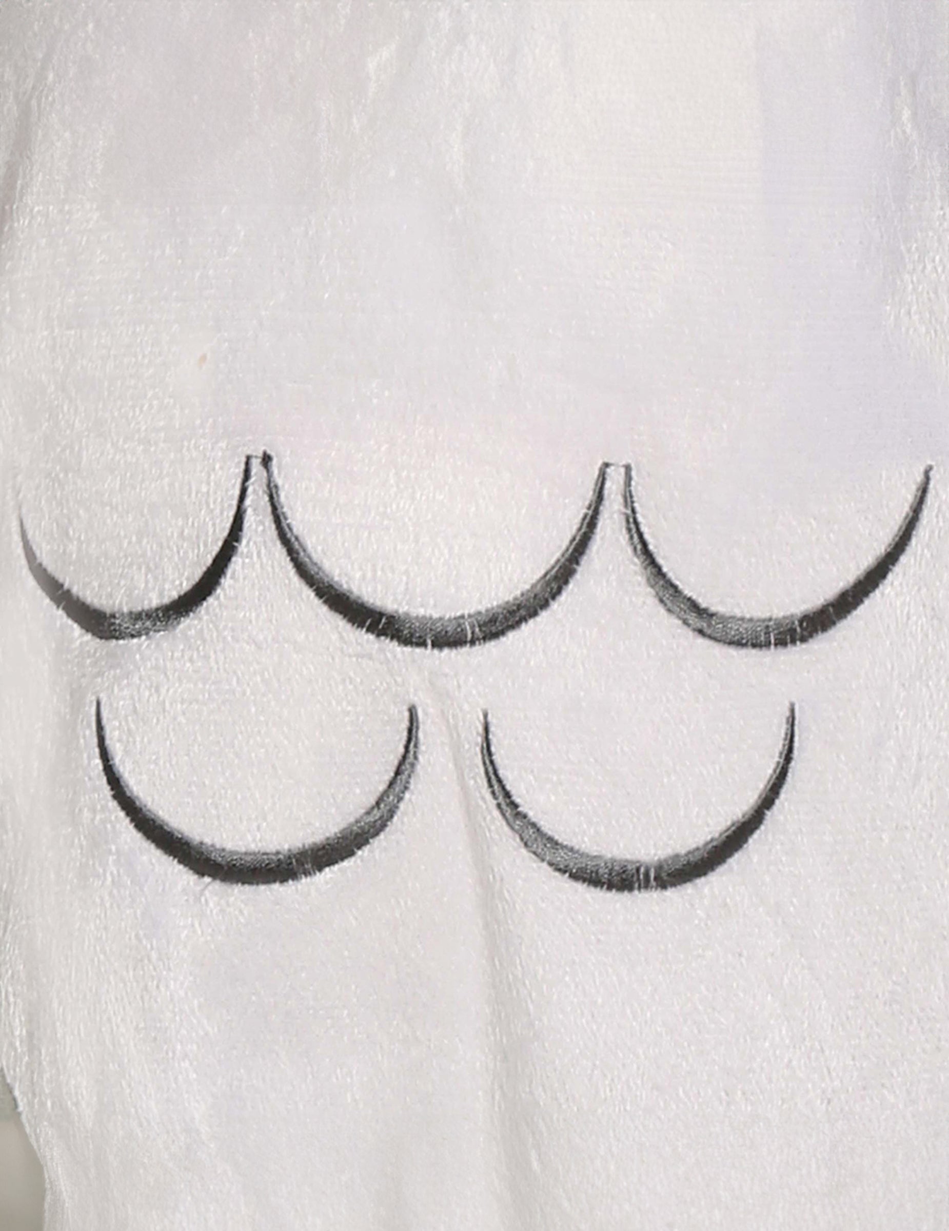 Gros plan sur les motifs de plumes du déguisement chouette magique pour bébé