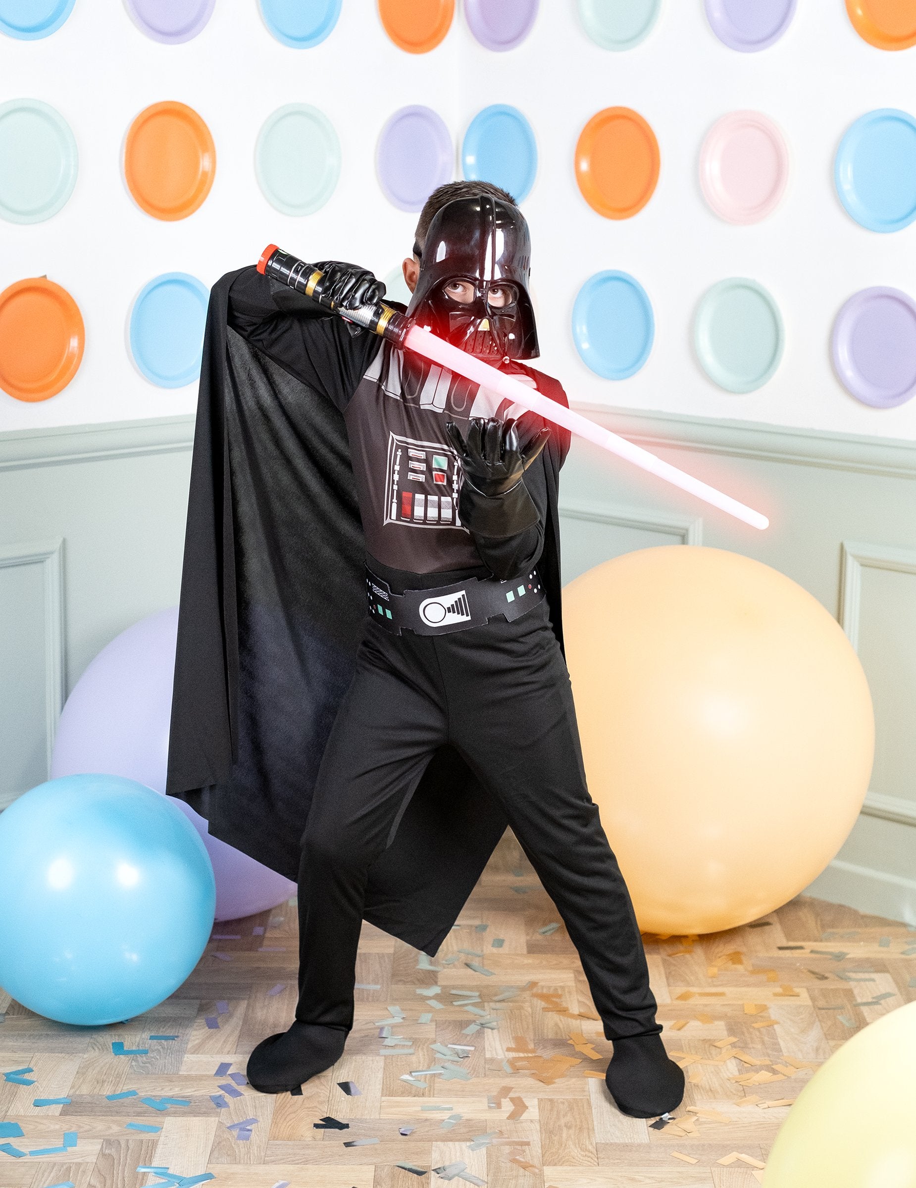 Pose de combat avec sabre laser du déguisement classique Dark Vador pour garçon