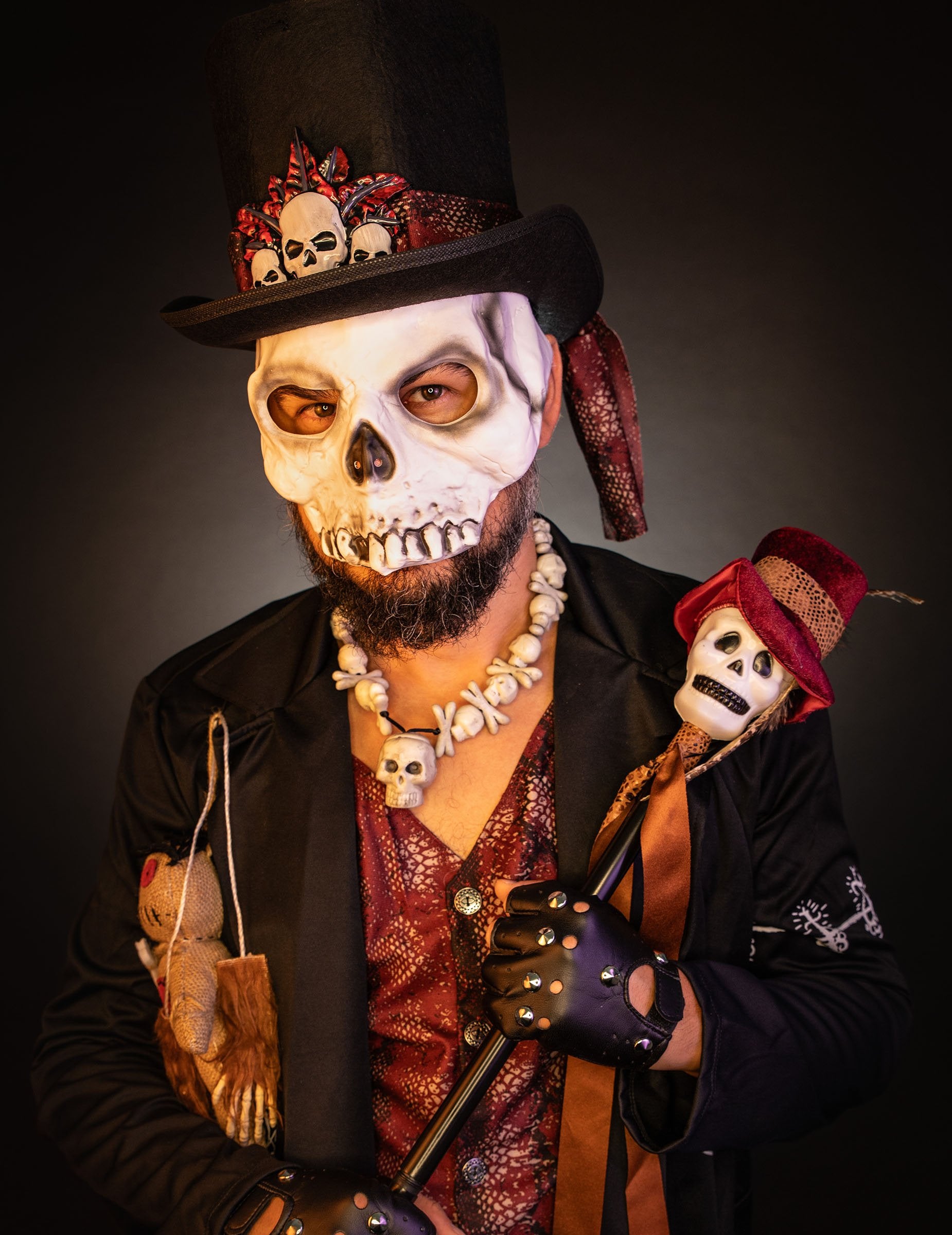 Gros plan sur le masque et le sceptre du déguisement de prêtre vaudou luxe pour homme