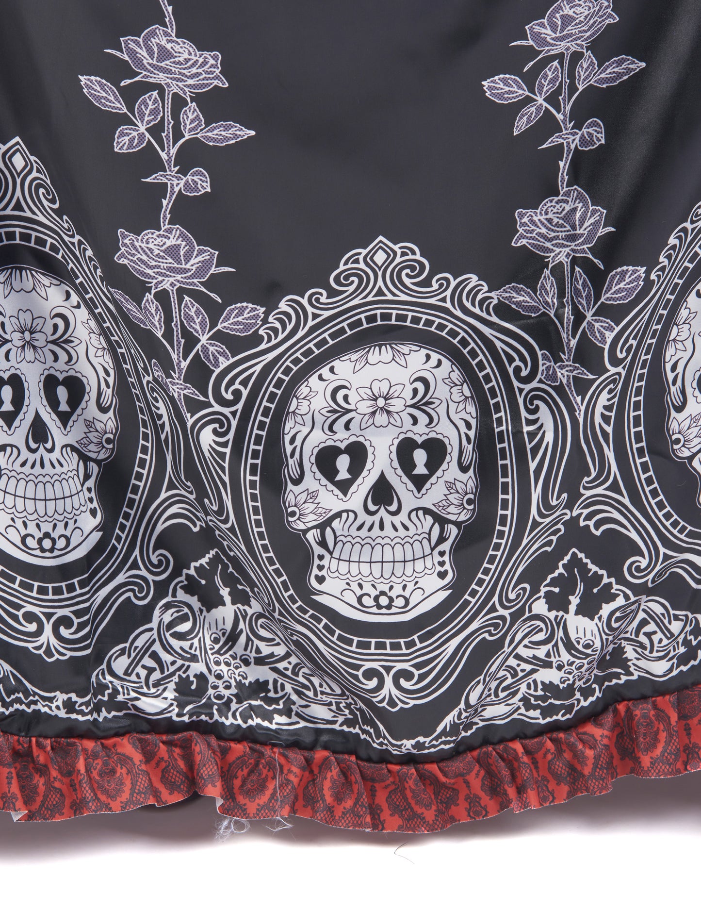Détail des imprimés têtes de mort et roses du bas du déguisement robe longue Dia de los muertos
