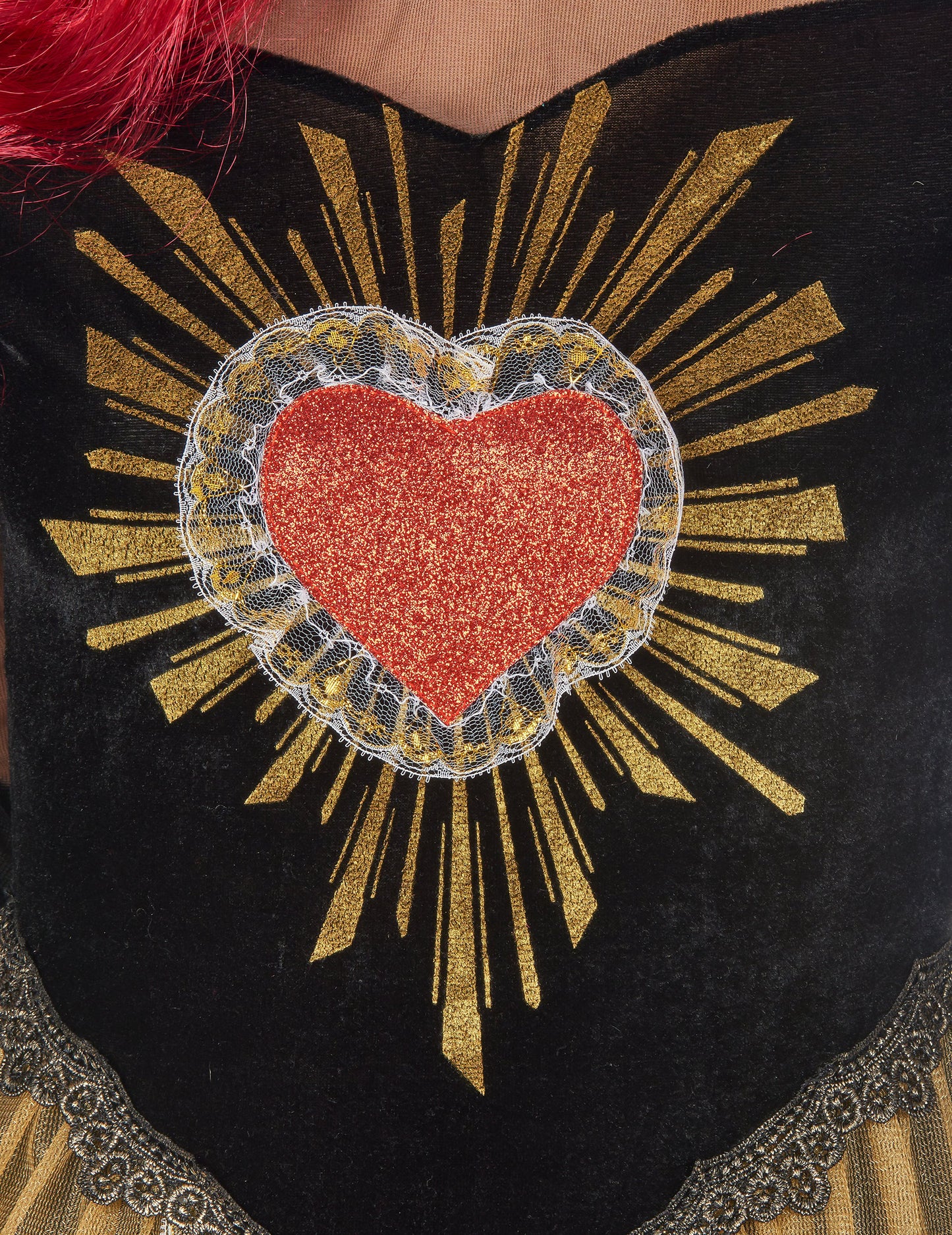 Détail du cœur rouge pailleté et des rayons dorés du déguisement reine du Dia de los muertos