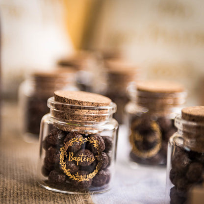 Gros plan sur le motif doré de la fiole en verre baptême couronne or