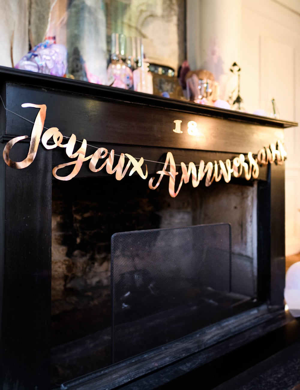 Mise en situation sur une cheminée de la guirlande Joyeux Anniversaire pour fête rose gold