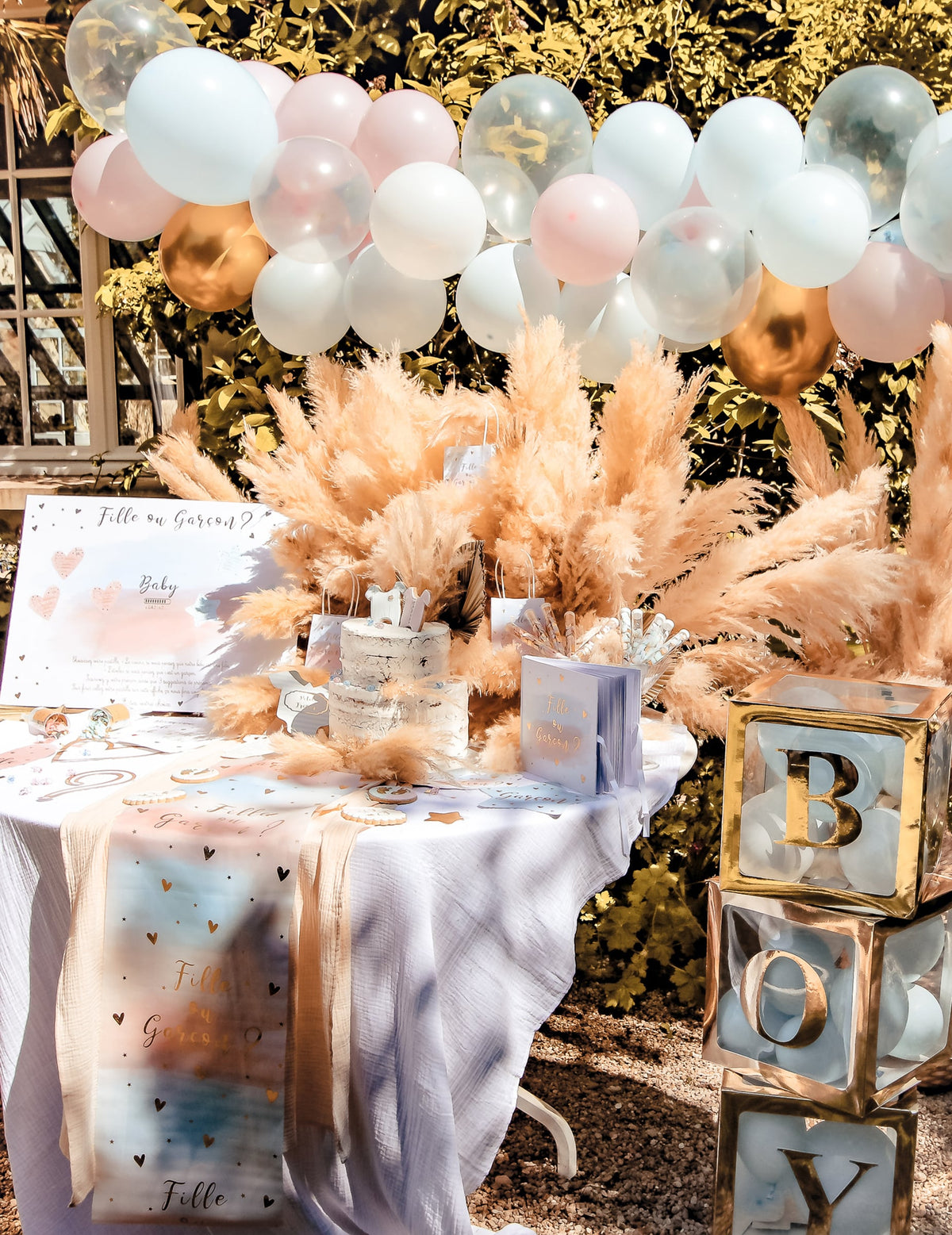 Mise en scène du Kit arche de 58 ballons gender reveal bleu et rose blanc et doré