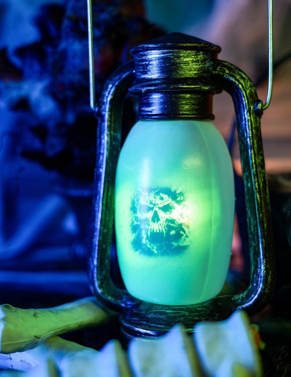 Gros plan sur le motif tête de mort éclairé en vert de la lanterne lumineuse d'Halloween