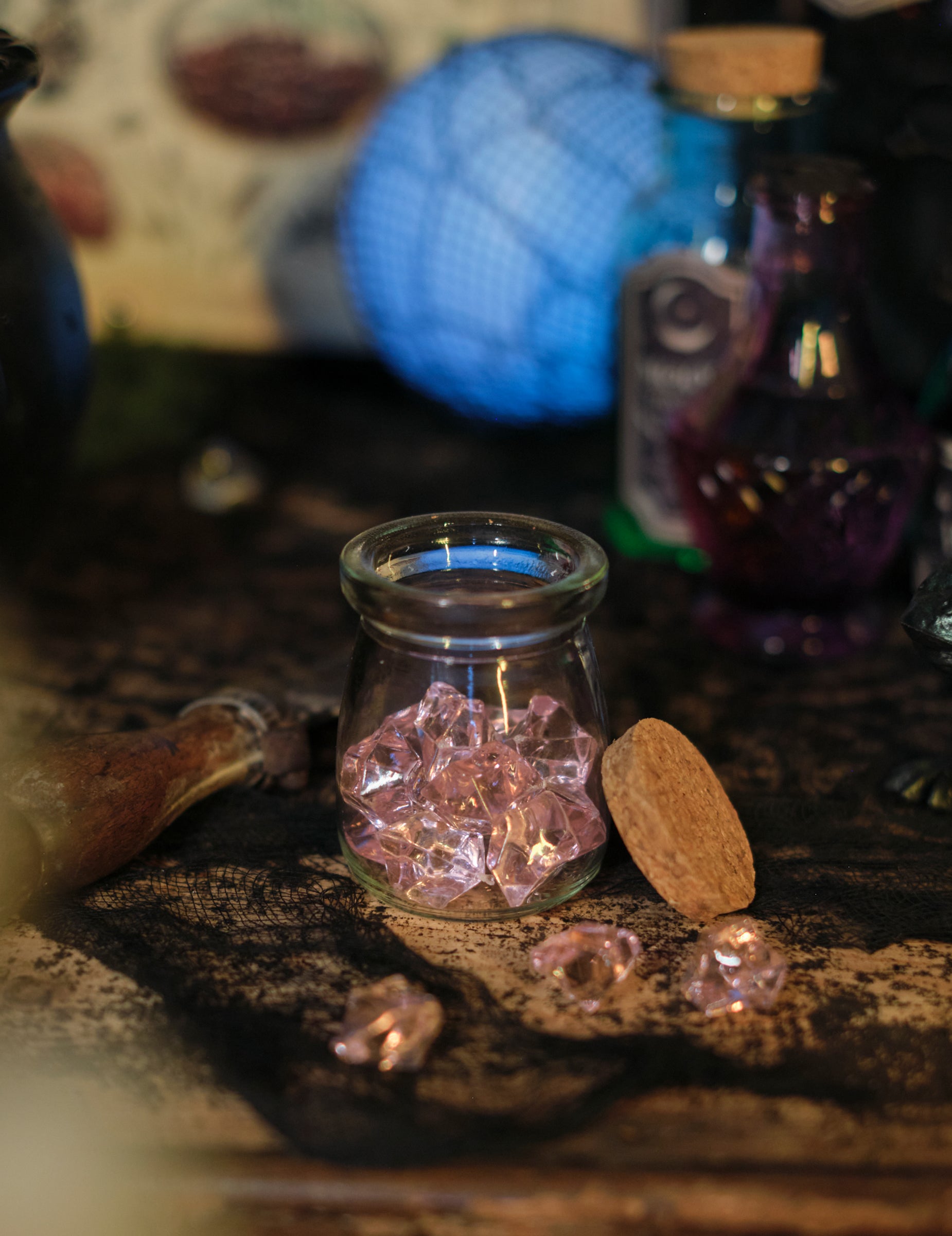 Bocal en verre contenant les pierres effet cristal pour décoration de table rose