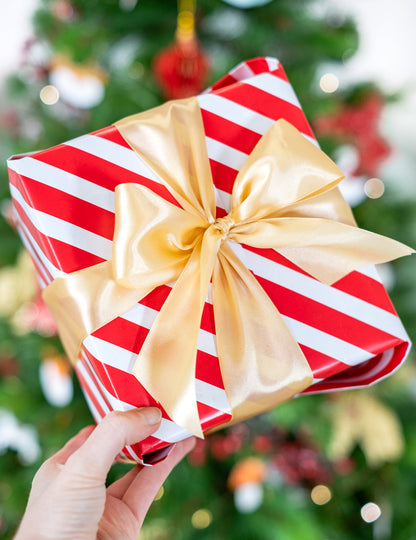 Nœud sur un emballage cadeau du ruban satin pour décoration doré ocre