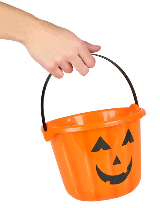 Detail rukojeti držené rukou na dýňovém kyblíku na halloween