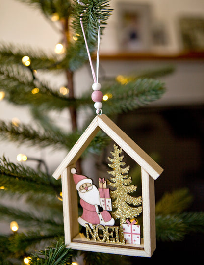 Mise en situation sur une branche de sapin de la suspension en bois maison du Père Noël