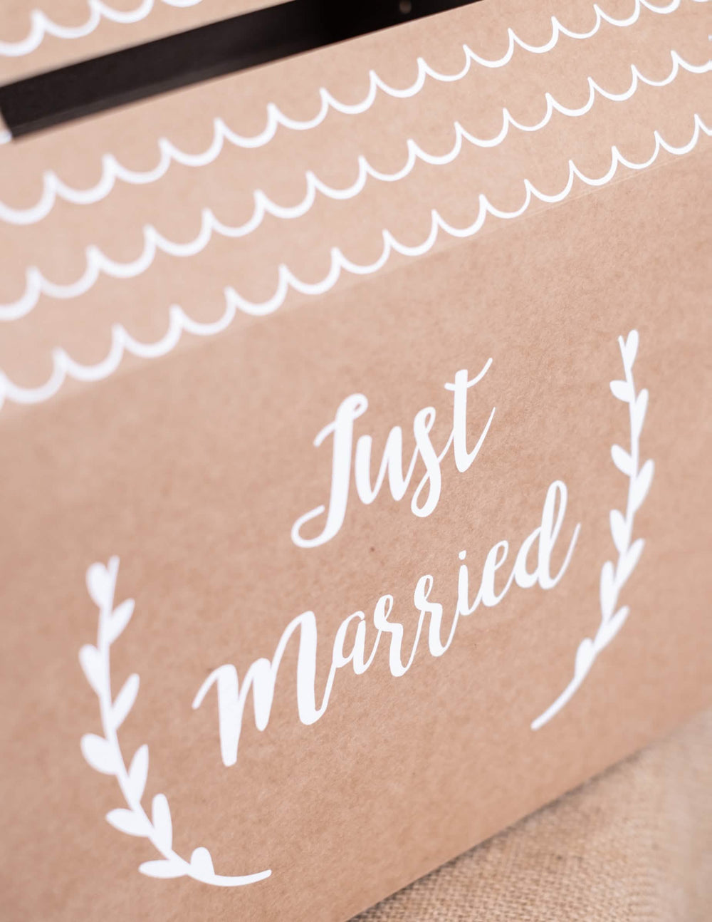 Detail na nápis na svatební pokladničce Just Married z kraftového kartonu ve tvaru domu