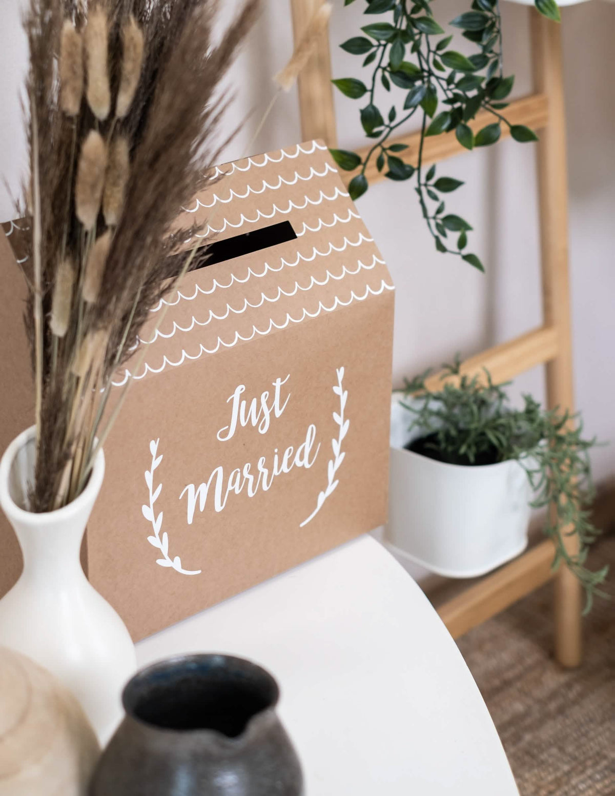 Pohled ze tří čtvrtin na kartonovou urnu z kraftového papíru Just Married ve tvaru domu