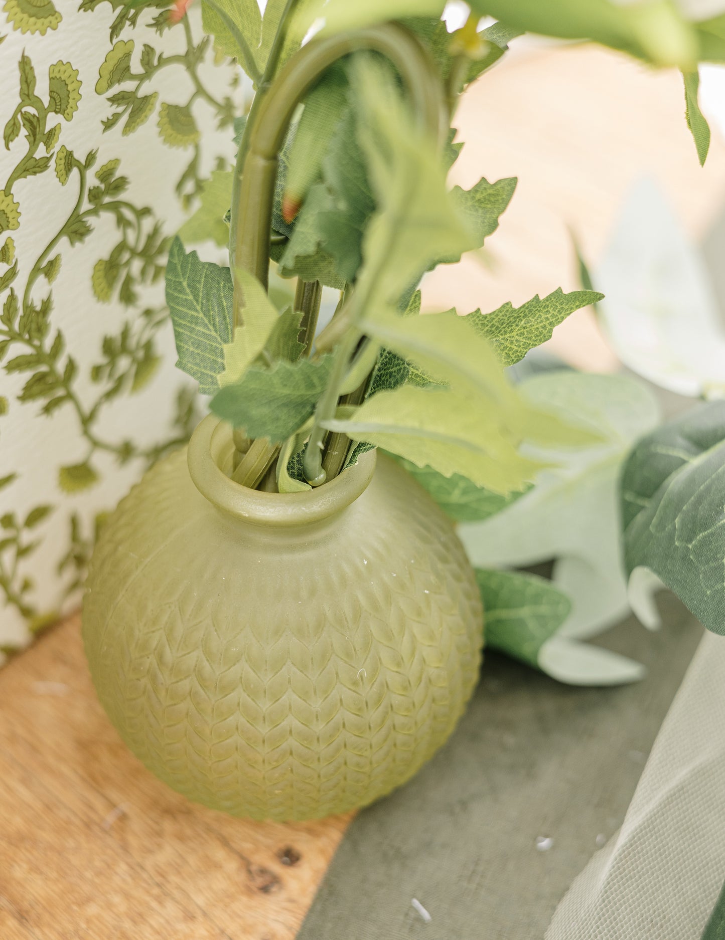 Gros plan sur le col et la texture du vase en verre ciselé style bohème