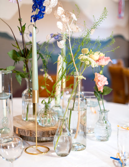 Composition décorative avec fleurs et bougies du vase soliflore en verre pour décoration